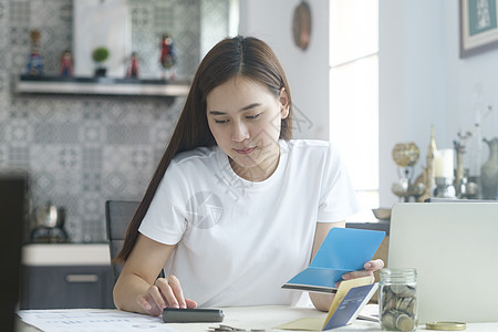 有吸引力的年轻亚洲妇女在家里工作通讯金融学习远程网络电脑自由职业者互联网工作者笔记本图片