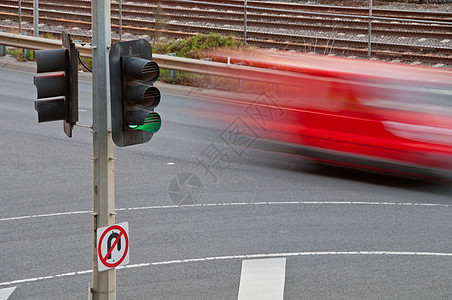 使用绿色交通灯杆移动模糊的红色汽车图片