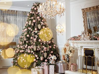 圣诞树站立起的客厅内地靠近壁炉礼品盒的地方 位于常青林附近的地毯上公寓盒子魔法风格礼物花环装饰假期庆典金子图片