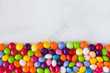 糖果色餐桌上的糖果 花彩多彩的甜甜糖宏观甜点味道品牌涂层火星饮食橙子团体热带背景
