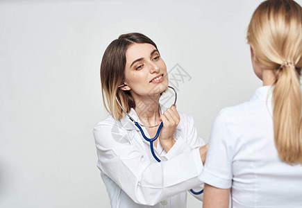 身着医疗礼服的护士医生向身穿白T恤的病人解释卫生成人访问从业者疾病男性讲话快乐考试治疗图片