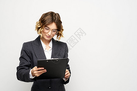 身着西装 证件在轻背景下持有文件的女商务人士 卷卷卷头发发型商务套装女士黑发女性幸福工人快乐女孩工作图片