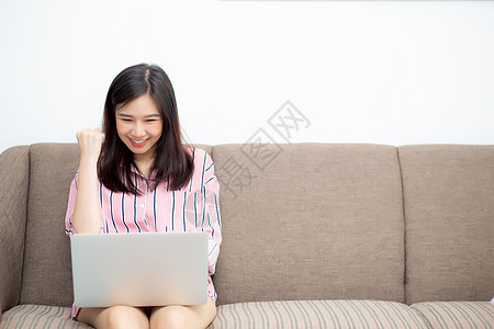 美丽的像一个年轻女性的肖像 兴奋和高兴的苏克笔记本房间商务项目沙发工作职业情感惊喜电脑图片