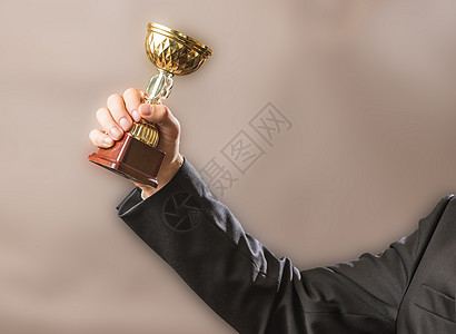 商务人士拥有冠军的金奖杯 成功和胜利的概念 是冠军的金奖杯团队杯子竞赛套装领导者优胜者庆典商务仪式领导图片