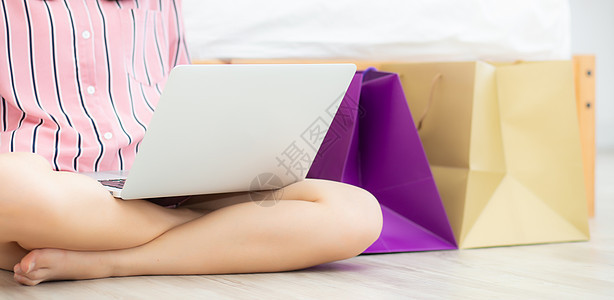 班纳网站Asian妇女网上用笔记本电脑购物图片