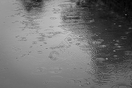 雨滴落到水坑里 在水上留下圆圈波纹反射液体人行道阴雨季节气泡水滴飞溅沥青图片