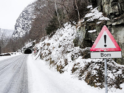 挪威的红路标是Bom和隧道 被雪覆盖的道路图片