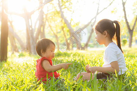 美丽的年青年轻小孩 夏天在公园玩耍的时候坐在公园里闲暇女孩幸福朋友们童年假期微笑女士快乐乐趣图片