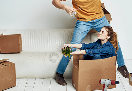 在沙发上装箱子的年轻夫妇 搬家 搬家了财产搬迁幸福抵押家庭房间公寓互联网成人微笑图片