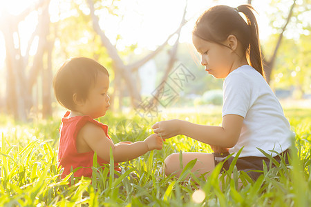 美丽的年青年轻小孩 夏天在公园玩耍的时候坐在公园里孩子们姐姐活动童年假期闲暇微笑幸福朋友们快乐图片