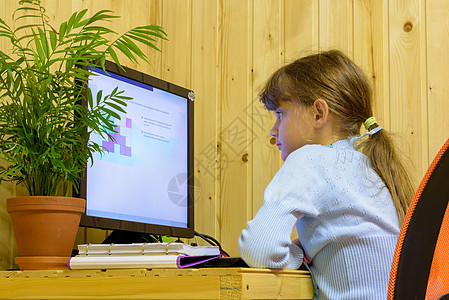 一个女孩在远程学习期间在计算机上解决问题图片