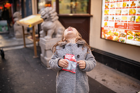 小女孩在她身后 带着中国龙的雕像歇斯底里地笑图片