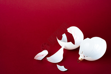 圣诞树的破碎弹珠装饰 红色背景上的白碎片 复制空间玩具气泡礼物碰撞季节粒子庆典脆弱性灾难新年图片