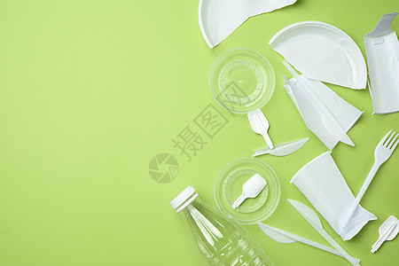 粉碎白色塑料餐具 绿色背面透明瓶图片