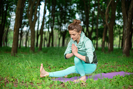 一个年轻运动女运动员在一个放弃的绿色夏日森林里做瑜伽 瑜伽屁股姿势 与自然的冥想和团结训练瑜珈力量健身房体操生活方式成人沉思哈达图片