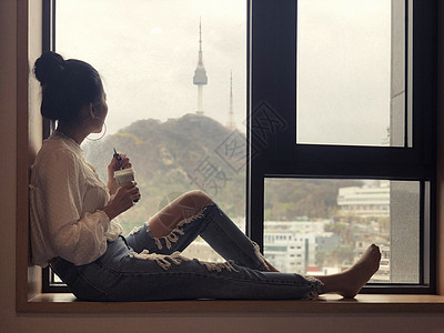 长头发女生年轻女孩喝咖啡 望着窗外看一眼背景