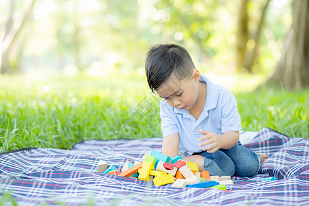 小男孩正在玩 想法和灵感与玩具块的游戏教育玩具学校公园乐趣房子喜悦婴儿幼儿园场地图片