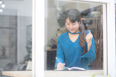 美丽的肖像 年轻的亚洲女作家在笔记本上写作作家学习教育商业女士咖啡店杂志思维日记学生图片