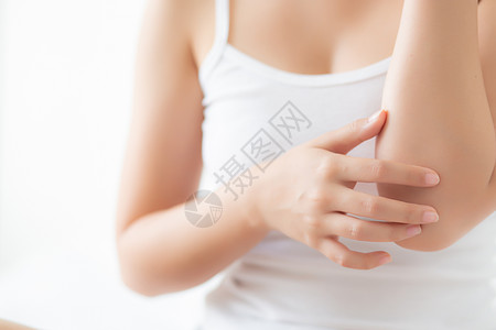 美貌的亚洲女性使用皮肤护理和moi近身手肘疙瘩划痕奶油疼痛保湿治疗女士客厅房间疾病图片