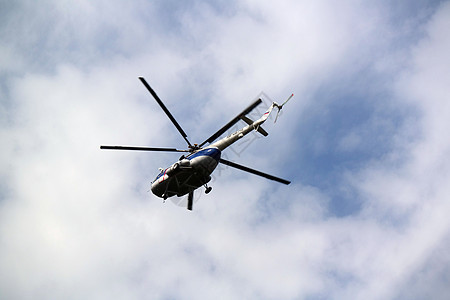 直升机在蓝云天空中飞行图片