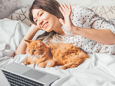 可爱的姜猫和女人躺在床上 女人就是问候图片