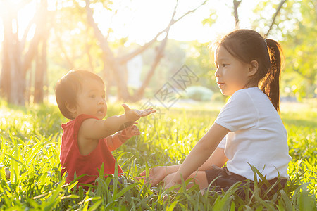 美丽的年青年轻小孩 夏天在公园玩耍的时候坐在公园里女士闲暇幸福假期姐姐快乐晴天孩子童年活动图片