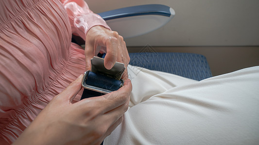 近身的女子系好飞机安全带带子座位航空公司紧固件乘客腰带航班危险警告预防图片