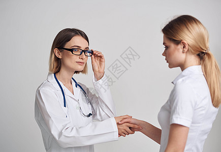 专业女医生和病人在浅色背景下握手处方疾病治疗咨询成人讲话办公室心脏病快乐女士图片