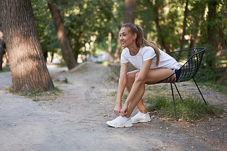 早上锻炼完之后 女性在椅子上系鞋带公园补水闲暇慢跑者运动鞋跑步有氧运动领带运动运动员图片