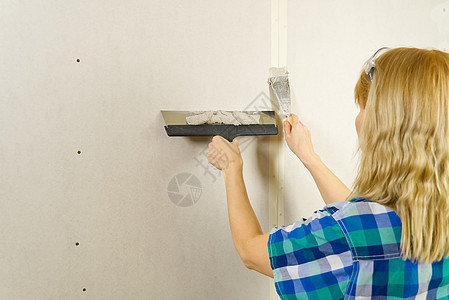 造型女室内工人用石膏工具在墙壁上涂抹泥土泥水匠改造承包商画家女性工作水泥装修女士建筑图片