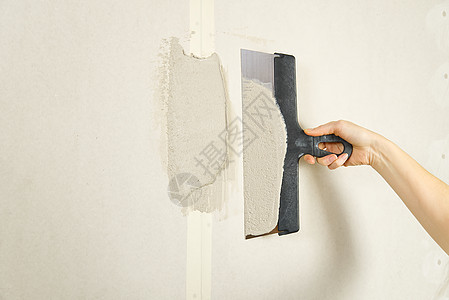 造型女室内工人用石膏工具在墙壁上涂抹泥土维修建筑水泥工作装潢师女士女孩泥水匠房间公寓图片