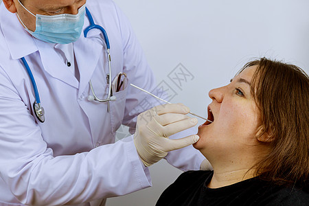 配有设备的保健工作者在Covid-19的口盘上对妇女进行冠状病毒检测图片