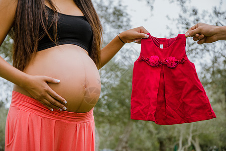 孕妇肚子旁边的红色礼服图片