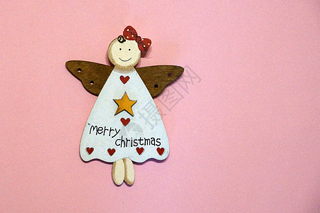 穿着粉红背景的圣诞礼服 复制空间的木木木天使图片
