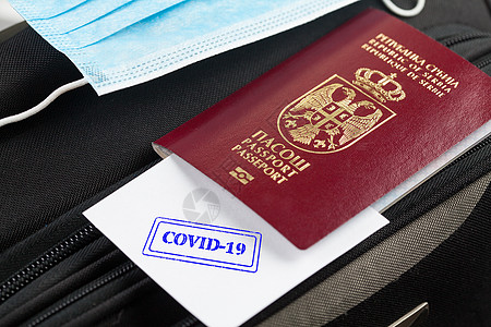 护照和医疗口罩在手提箱上图片