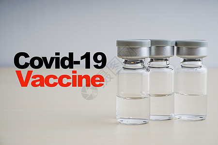 COVID  19 VACCINE 文本 木本上装有小瓶药物免疫科学家治疗液体感染诊所剂量疫苗实验室图片