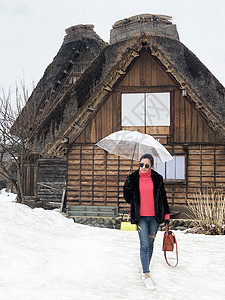 在冬季和Sno时持透明伞的女旅游者假期女性观光女孩历史房子地标建筑学成人街道图片