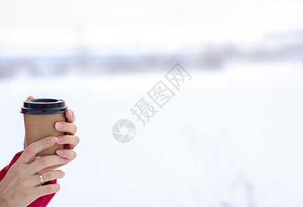 冬天的年轻女子 喝杯热咖啡或茶酿造公园塑料饮料女孩商业液体雪花热饮女士图片