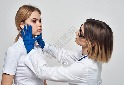 身穿医疗长袍和蓝色手套的女医生 脖子上戴着听诊器 还有一名女病人男性护士成人生活治疗心脏病疾病快乐访问诊所图片