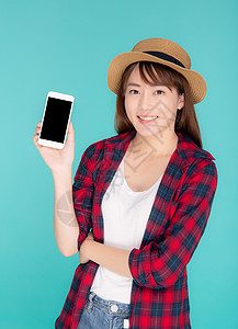 美丽年轻的年轻女士 展示智能手机作为预发版潮人闲暇技术旅游青少年蓝色学生电话成人细胞图片