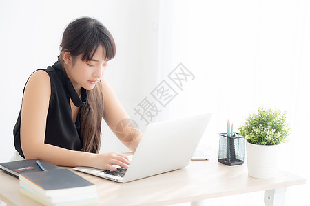 美丽的年轻自由职业青年女性 在工作 打字时微笑教育网络桌子女孩女士秘书检查互联网闲暇商务图片