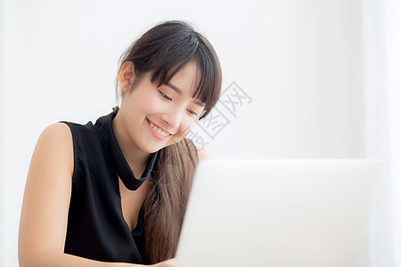 美丽的年轻自由职业青年女性 在工作 打字时微笑闲暇技术检查商务笔记本女士办公室教育互联网客厅图片