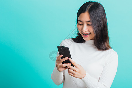 妇女微笑 她拿着并打短信女士女性阅读手机技术社会学生互联网短信细胞图片