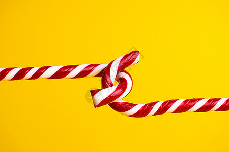 黄色背景的糖果甘蔗棒棒棒糖 圣诞甜点螺旋传统季节装饰品食物焦糖薄荷庆典礼物条纹图片