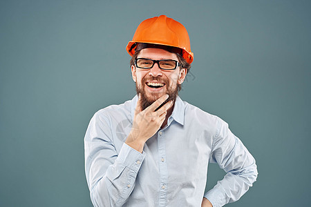 穿着橙色硬帽衬衫的快乐男人 用手牵手穿衣做工工程工程师职业承包商男性工人帽子领班头盔情感工作室蓝色图片