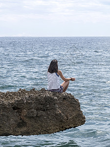 美丽的女人 在日出时在海滩上做瑜伽岩石成人思维假期女孩海岸石头地平线活力沉思图片