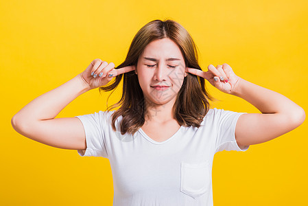 女人的笑容 有闭紧的掌耳朵和手掌情感黄色音乐压力手势女孩学生工作室生气女性图片