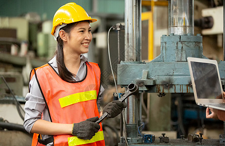 在工厂内操作Cnc机的工程师男性技术讨论冶金笔记本女性作坊金工导师工作图片