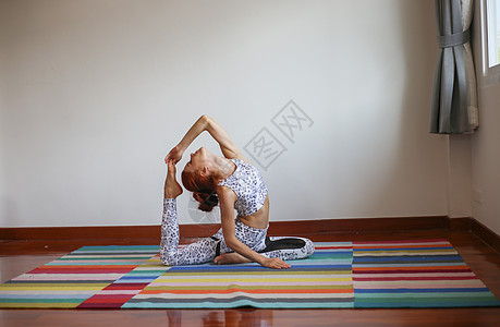 妇女在家里做瑜伽冥想运动装练习体操地面训练女性沉思女孩运动图片