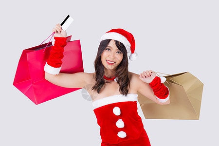 美丽的肖像年轻亚洲女人微笑着拿着信用卡和购物纸袋 兴奋地孤立在白色背景上 美丽的亚洲女孩在圣诞节或新年假期购买和付款图片